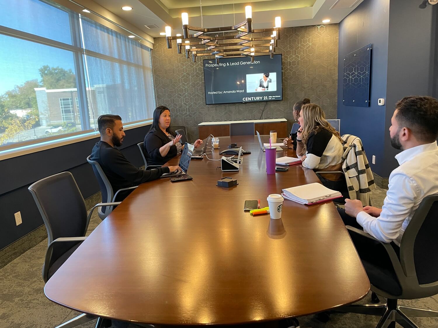 Group of people at a board room table, prospecting and farming